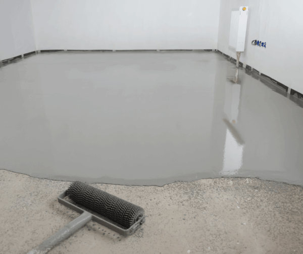 Paint roller on freshly poured gray floor cement